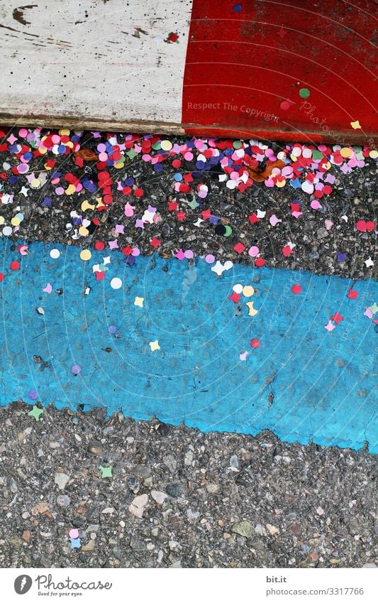 Colorful confetti lies on dirty Thursday, during carnival; carnival on the street on the ground, between markings as warnings, at a carnival parade, and pollutes the environment