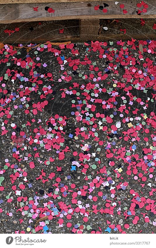 *1700* - colourful confetti made of paper, lying on the street after a carnival and carnival celebration, spread out on the street and waiting for the street sweeper.