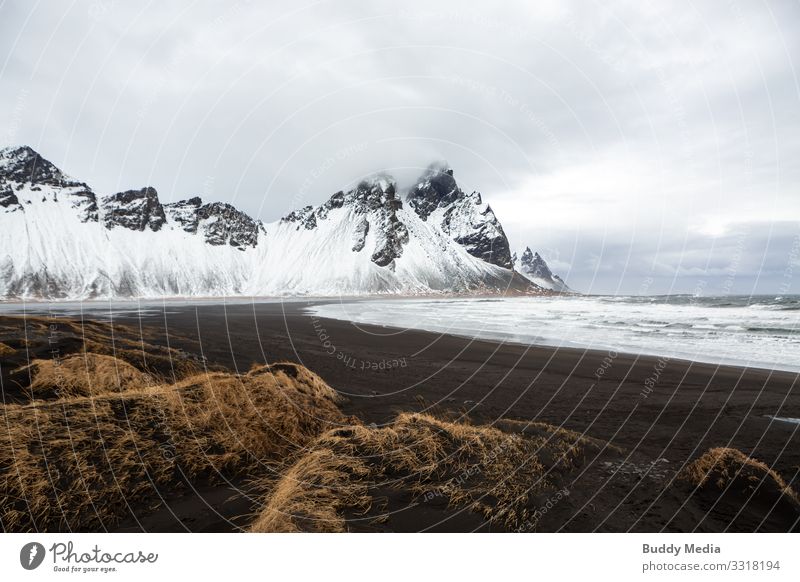 Stokksnes - Black Sand Beach in Iceland Vacation & Travel Expedition Mountain Nature Landscape Earth Water Sky Clouds Spring Weather Wind Grass Rock Waves Coast
