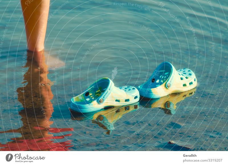 rubber slippers float in clear water next to female legs Ocean Human being Woman Adults Couple Feet Nature Pond Lake Footwear Slippers Movement Natural Clean
