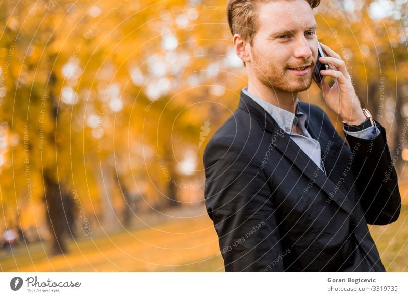 Young man with mobile phone in the autumn park Lifestyle Style To talk Telephone PDA Technology Human being Youth (Young adults) Man Adults 1 18 - 30 years