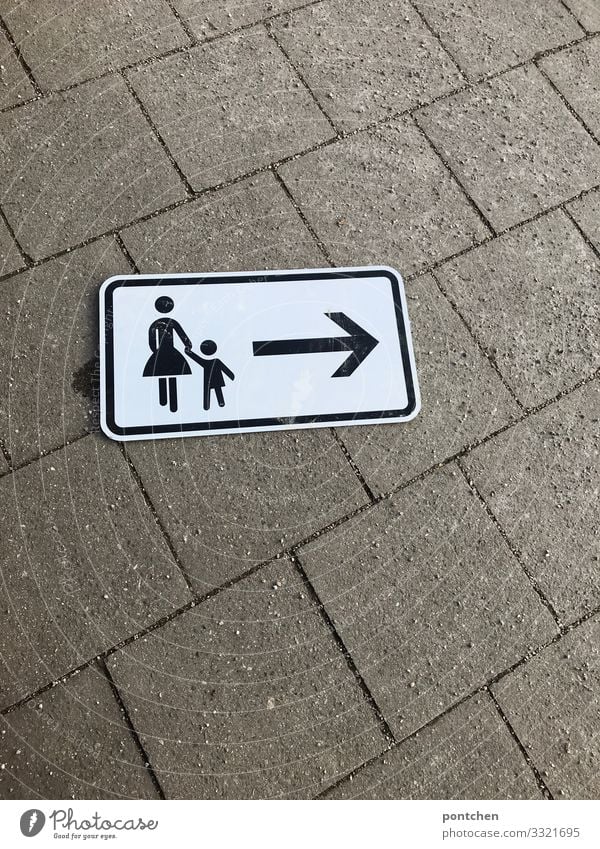 Street sign Pedestrian path is on the ground. Arrow. Mother and child Human being Masculine Feminine Child Toddler Girl Boy (child) Woman Adults 2 1 - 3 years