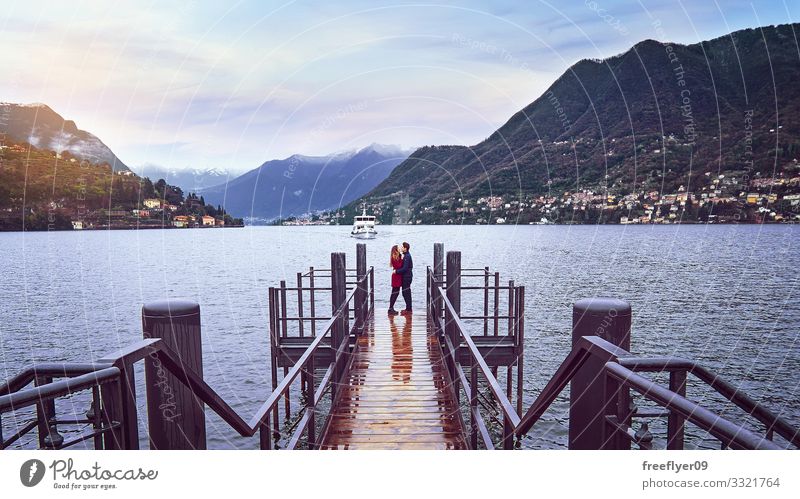 Young couple kissing on the deck of Lago di Como in Italy Relaxation Calm Vacation & Travel Summer Mountain Wedding Human being Masculine Feminine Woman Adults