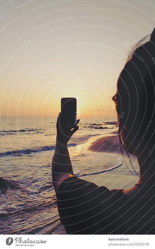 Girl is taking a sunset photo on the mobile phone Vacation & Travel Summer Beach Ocean Cellphone PDA Technology Woman Adults Hand Environment Nature Landscape