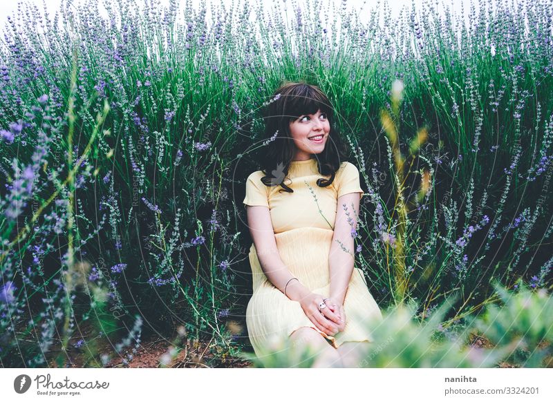 Young brunette woman sitting surrounded by lavender young pretty retro vintage nature natural real candid relax tranquility scene flowers spring springtime