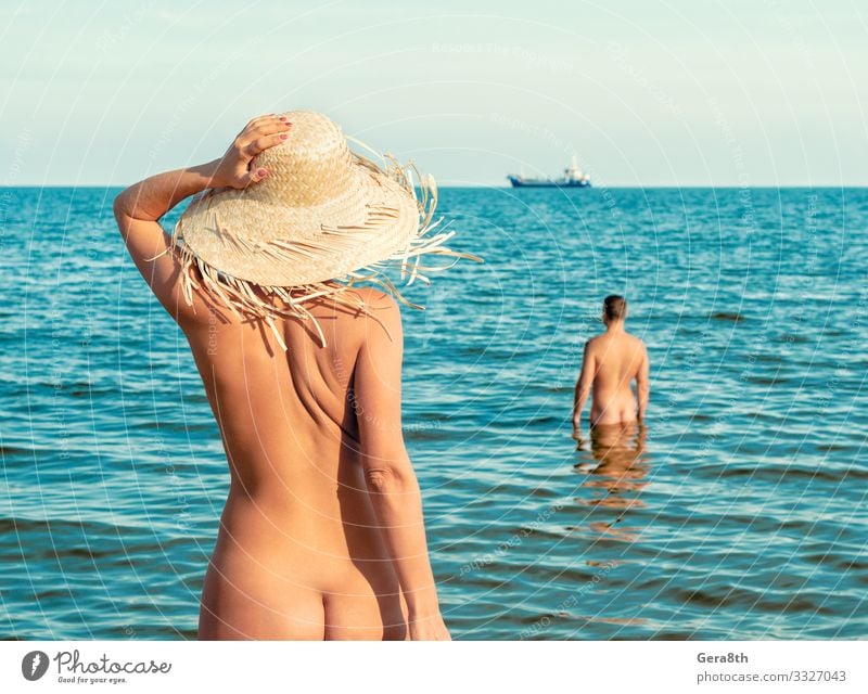 naked girl in a straw hat on the beach and a naked man stands in the water Skin Vacation & Travel Summer Ocean Island Waves Woman Adults Man Couple Hand Nature