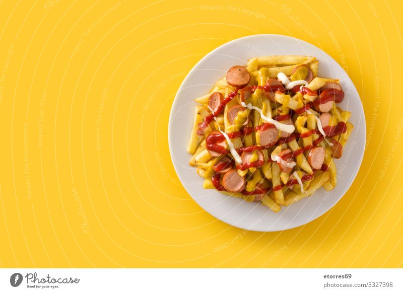 Typical Latin America Salchipapa on yellow background. Black Dinner Fast food Fat Food Food photograph French fries Fries Ketchup Lunch Mayonnaise Mix Mustard