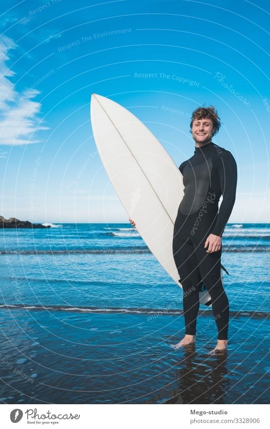 Surfer standing in the ocean with his surfboard. Lifestyle Joy Happy Relaxation Leisure and hobbies Adventure Beach Ocean Waves Sports Aquatics Human being