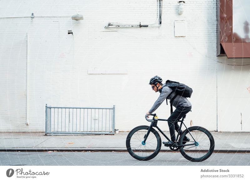 Professional cyclist with smartphone man bicycle bike city street asphalt road equipment eyeglasses male helmet sport lifestyle movement urban messenger wheel