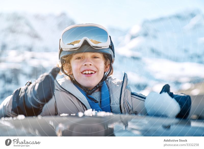Cheerful boy making snowball in car winter smile roll resort sunny daytime kid child recreation lifestyle happy cheerful delighted optimistic vehicle auto