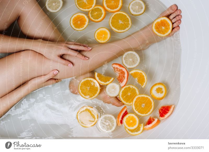Woman's hand and legs in a bath filled with water Aromatic Swimming & Bathing Bathroom Bathtub Beauty Photography Bomb Bubble care Lemon Citrus fruits Clean