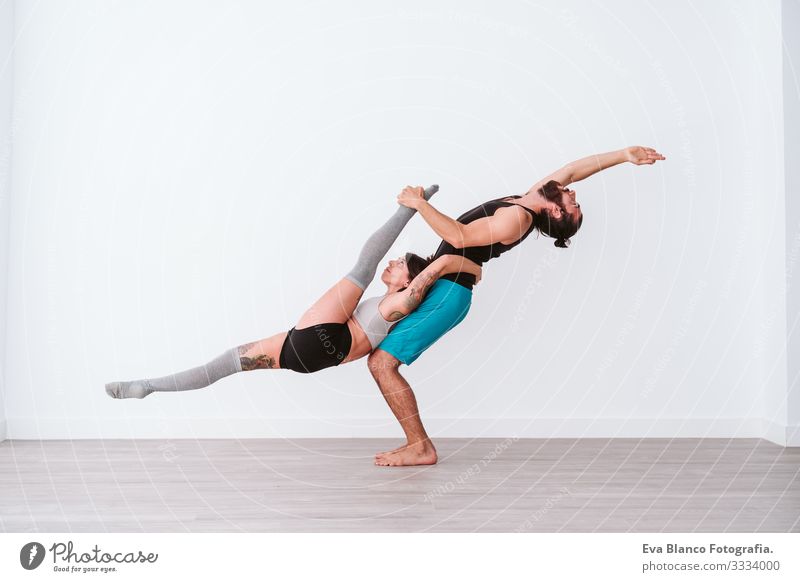 Young Couple Couple Practicing Acro Yoga In White Studio Or Gym. Healthy  Lifestyle - A Royalty Free Stock Photo From Photocase