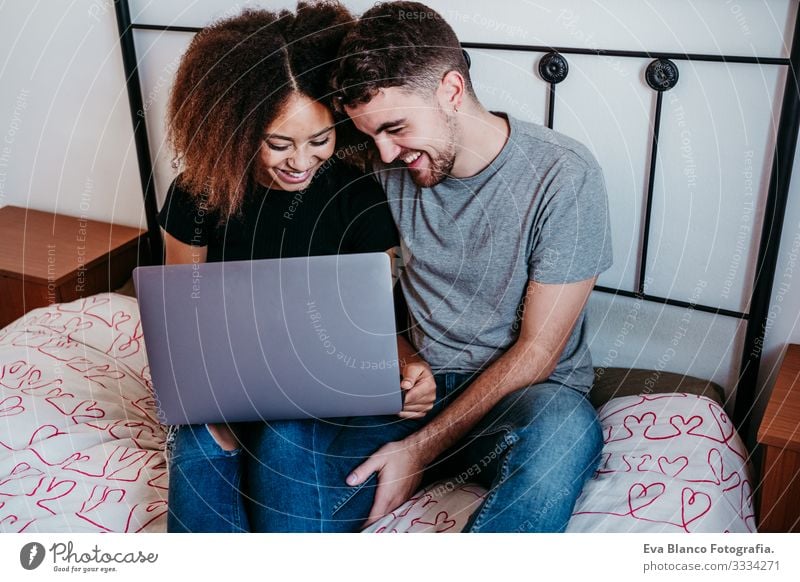 happy couple in love at home. Afro american woman and caucasian man using laptop. ethnic love concept Notebook Technology Couple Love African-American Ethnic