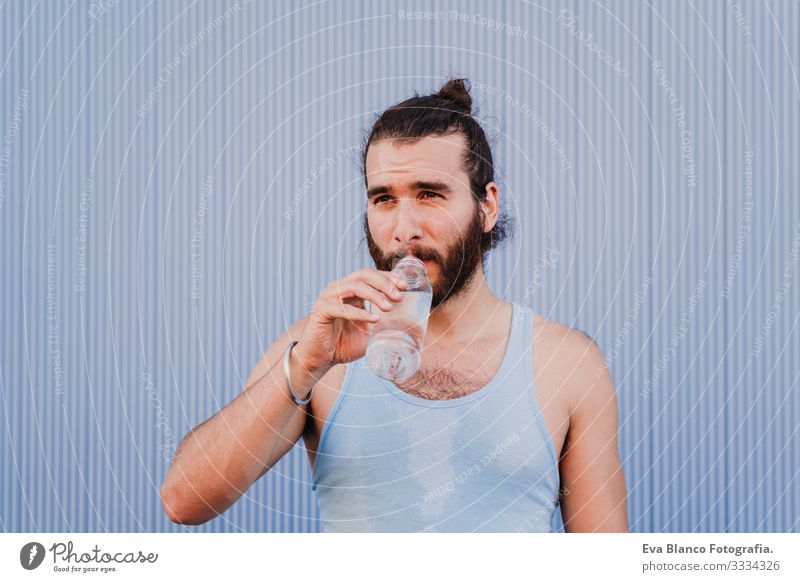 man in the city practicing yoga sport and drinking water. blue background. healthy lifestyle Yoga Man Sports Healthy Exterior shot City Blue background Muscular