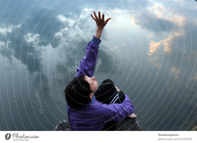 young woman stretches her hand into the sky, which is reflected in a lake Relaxation Calm Girl Young woman Youth (Young adults) Hand 1 Human being Dream Water