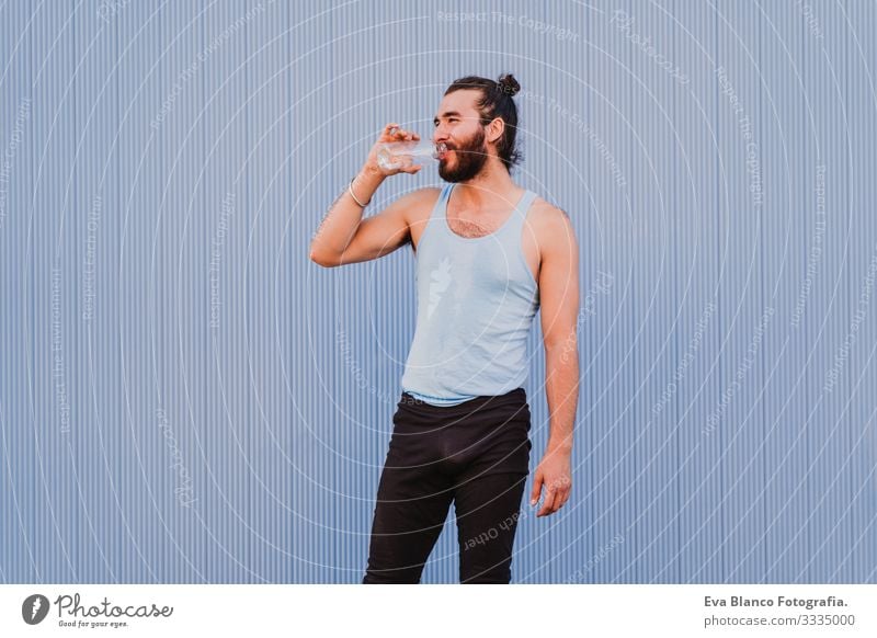 man in the city practicing yoga sport and drinking water. blue background. healthy lifestyle Yoga Man Sports Healthy Exterior shot City Blue background Muscular