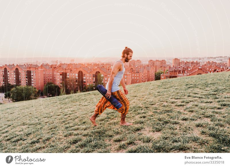young man in a park ready to practice yoga sport. city background Man Youth (Young adults) Yoga Sports City Park Sunset Lifestyle Healthy Mat sport clothes