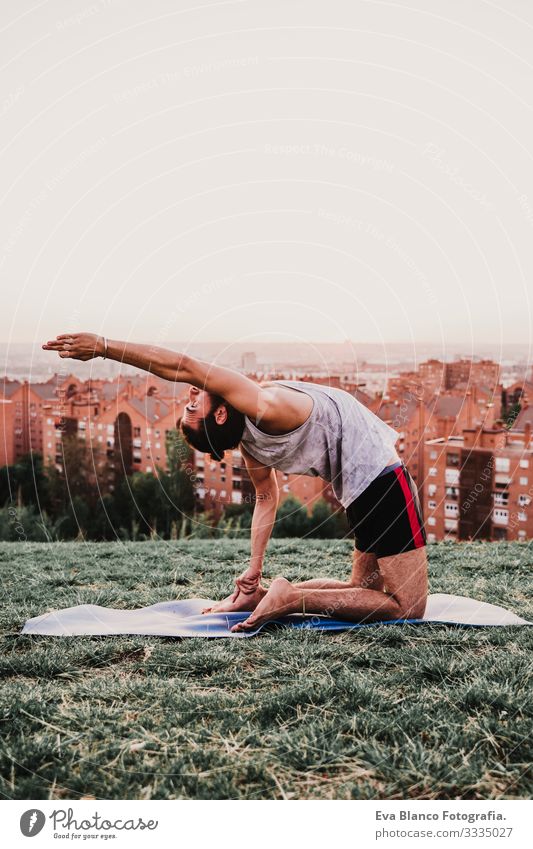 young man in a park practicing yoga sport. city background. healthy lifestyle. Man Youth (Young adults) Yoga Sports City Park Sunset Lifestyle Healthy Mat