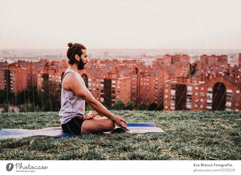 young man in a park practicing yoga sport. city background. healthy lifestyle. Man Youth (Young adults) Yoga Sports City Park Sunset Lifestyle Healthy Mat