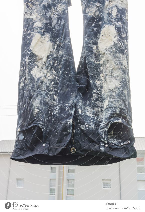 Heavy work pants of a painter hangs in front of an apartment block Profession Craftsperson Craft (trade) Construction site Hard labor