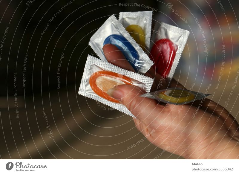 Full hand with coloured condoms Hand Packing material Colour Condom AIDS Protection Safety Sex Sexuality Family planning Contraceptive Latex Dangerous Risk