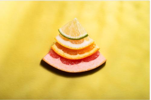 Citrus fruits slices in sunlight. Mix of citrus fruits Food Fruit Orange Nutrition Fresh Bright Sweet Multicoloured Yellow Red above view cheerful citrus stack