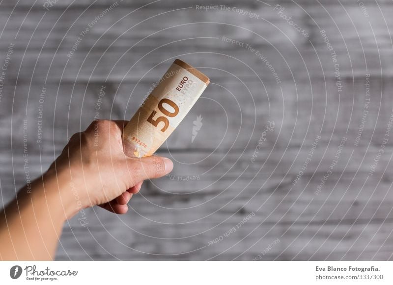 woman hand holding cash isolated on grey wood background. Euro fifty bills. European Money wealth Hold payment Financial Financial institution Business