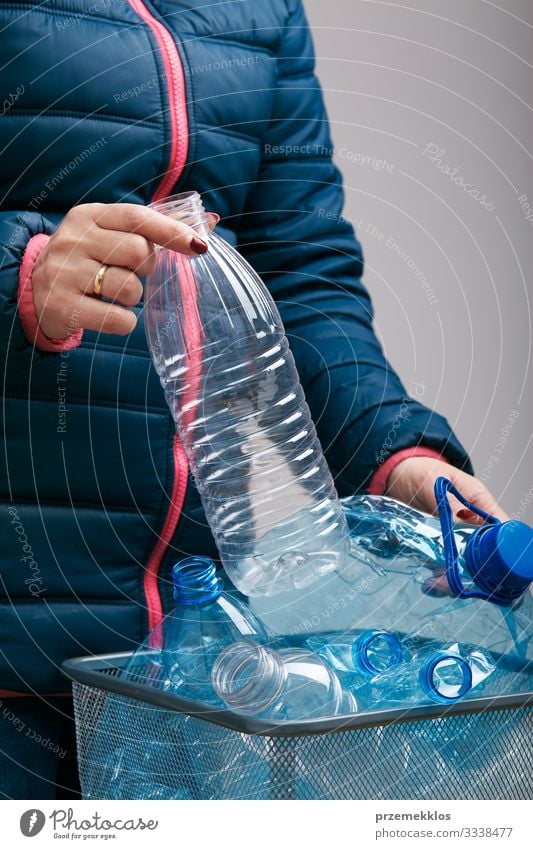Woman collecting used plastic bottles in trash bin Bottle Adults Body Environment Container Package Plastic Throw Blue Environmental pollution Trash recycle