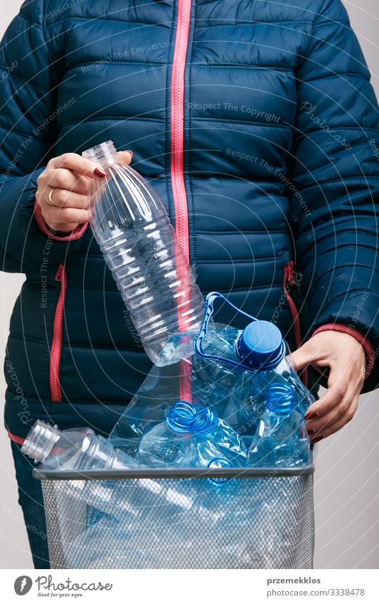 Woman collecting used plastic packagings in trash bin Bottle Adults 1 Human being Environment Container Package Plastic Throw Blue Environmental pollution Trash