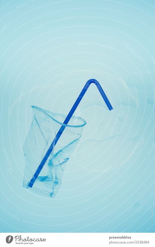 Squashed plastic cup and drink straw over blue background Save Environment Container Plastic Blue Environmental pollution Trash garbage recycle Recycling