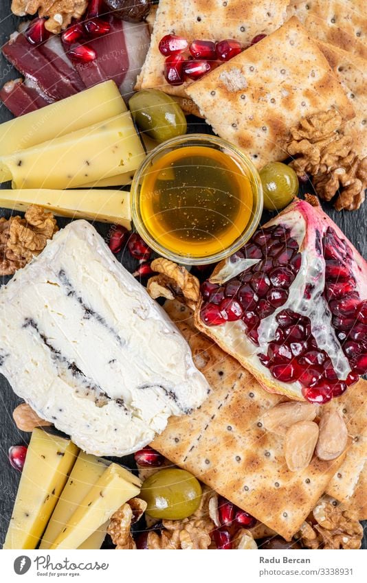 Food Platter With Truffle Cheese, Duck Breast, Brie Cheese, Pecan Nuts, Pomegranate Seeds, Grapes, Almonds, Honey, Olives and Crackers crackers almonds