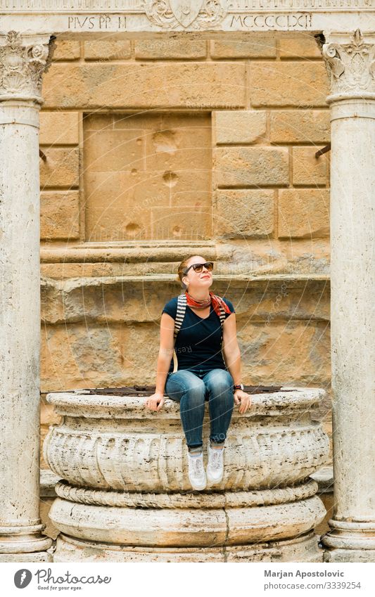 Young woman sitting on a well in old town Tuscany Lifestyle Vacation & Travel Tourism Trip Sightseeing City trip Human being Feminine Youth (Young adults) Woman