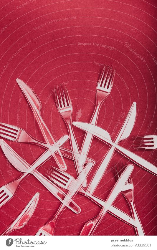 Plastic cutlery scattered over red background Cutlery Fork Save Environment Container Red Environmental pollution Environmental protection Trash garbage recycle