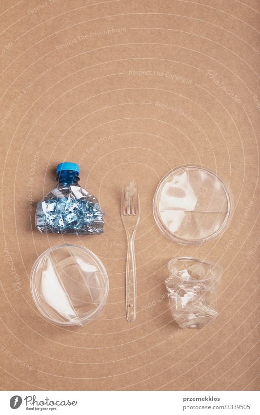 Squashed plastic bottle, box, cup and fork over cardboard Bottle Fork Save Environment Container Packaging Plastic packaging Crystal Blue