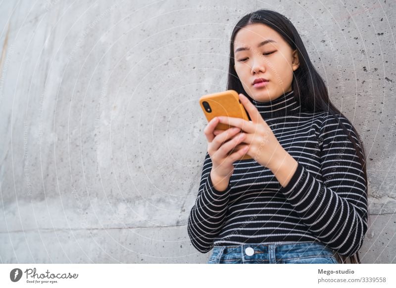 Asian woman using her mobile phone. Lifestyle Beautiful Reading To talk Telephone PDA Technology Human being Feminine Girl Woman Adults 1 18 - 30 years