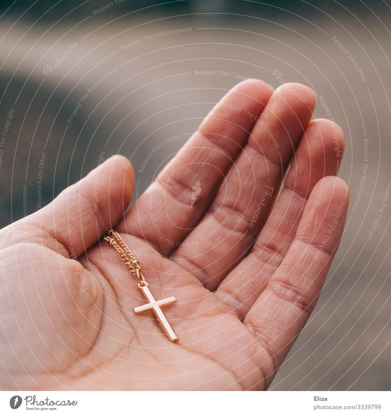A person holds a golden crucifix in his hand. Faith and Christianity. Human being Hand 1 Belief Religion and faith Christian cross Crucifix Catholicism