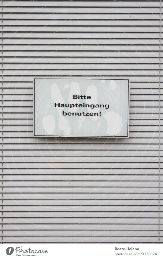 Printed product l Sign "Please use main entrance" in front of cross-striped blind Print product sign Signage Information invitation Signs and labeling