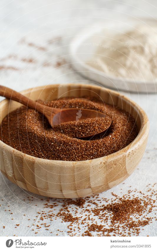 Raw teff grain in a bowl and teff flour close up Vegetarian diet Diet Spoon Table Wood Natural Brown White Flour Cereal dry food gluten free health healthy Heap