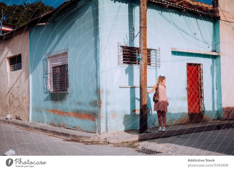 Female tourist with backpack at city street woman tourism walking stroll dress gown architecture exterior explore female cuba travel vacation holiday lifestyle