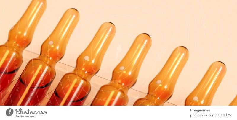 Serum B12 with vitamin C in ampoules for medical treatment. horizontal perspective view of many brown ampoules placed in pharmaceutical packaging containers. Vitamin concept