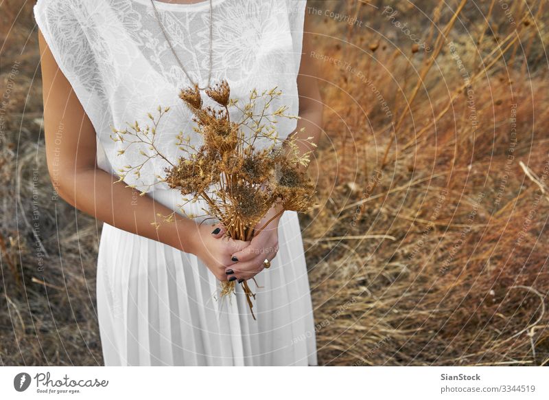 Young woman with white dress holding a bouquet of dry flowers. Human being Woman Adults 1 Nature Landscape Flower Clothing Dress To enjoy Colour photo