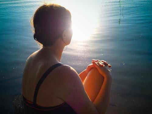 15 minutes daily Sunbathing Summer Lake Swimsuit Brunette Braids Sit Warmth Safety (feeling of) Attentive Experience Serene Break Senses Sunlight Upper body