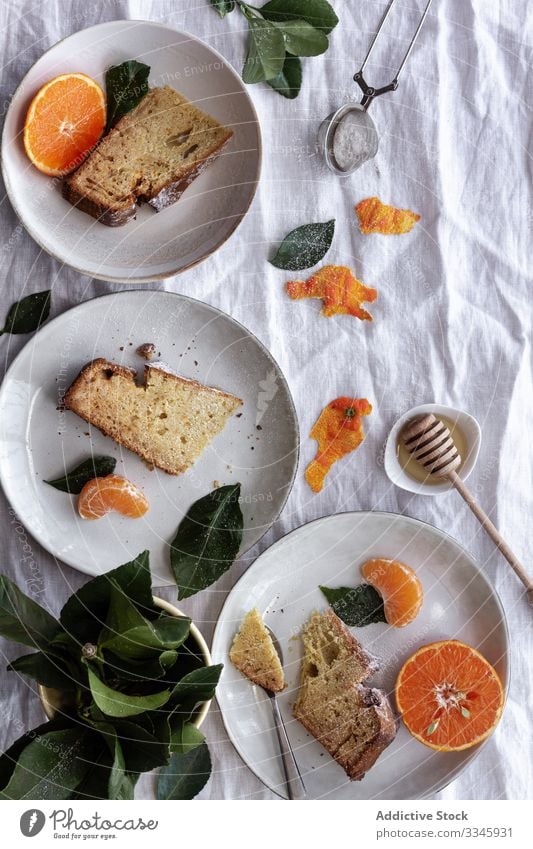 Sliced cake and citruses on plates on table tangerine fruit dessert sliced portion eating orange sweet mandarin pastry gourmet delicious cookie creative healthy