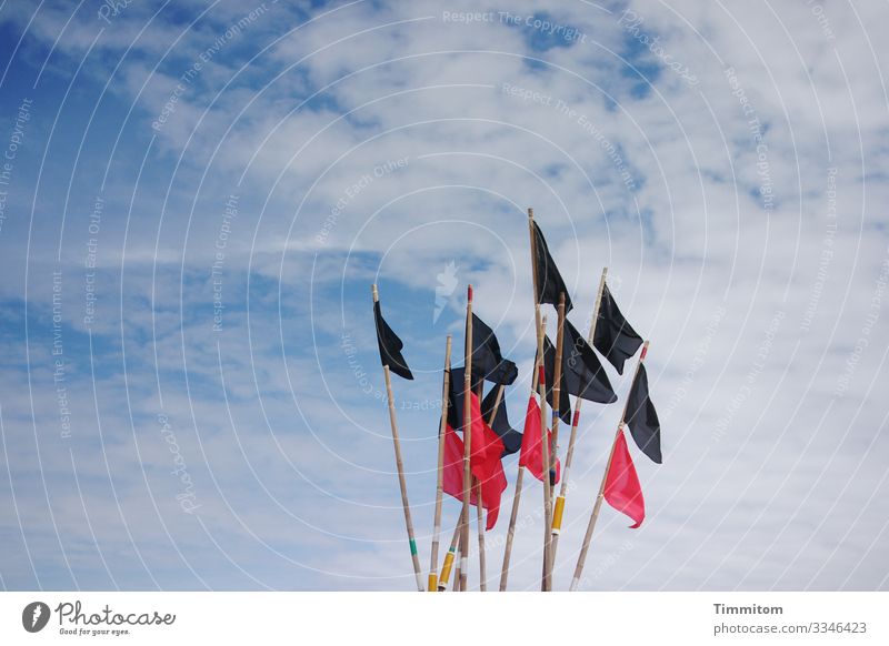 Black and red flags of a fishing boat in front of a cloudy sky Flag Red Sky Clouds poles Blue White Fishing boat North Sea
