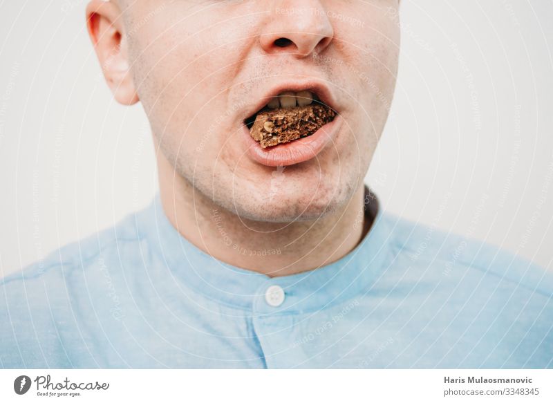 Man Eating chocolate close up Food Diet Feeding Candy Cookie Calorie Mouth Colour photo Interior shot Studio shot Copy Space left Copy Space right Flash photo