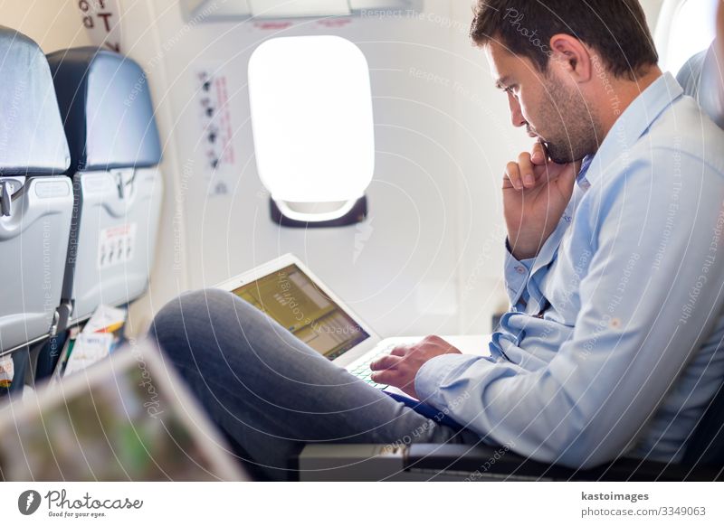 Businessman working with laptop on airplane. Lifestyle Reading Vacation & Travel Trip Work and employment Economy Computer Notebook Human being Man Adults Hut