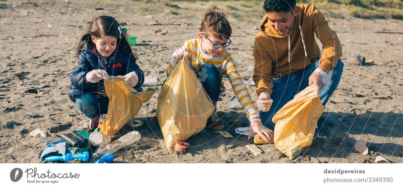 Young volunteers cleaning the beach Happy Camping Beach Child Internet Human being Boy (child) Woman Adults Man Group Environment Sand Plastic Smiling Dirty