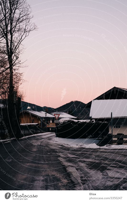Icy road with snow-covered houses at dusk in winter Winter Street Ice Snow Dusk sunset Village Bavaria Red Village road Landscape Frost chill Evening Tracks