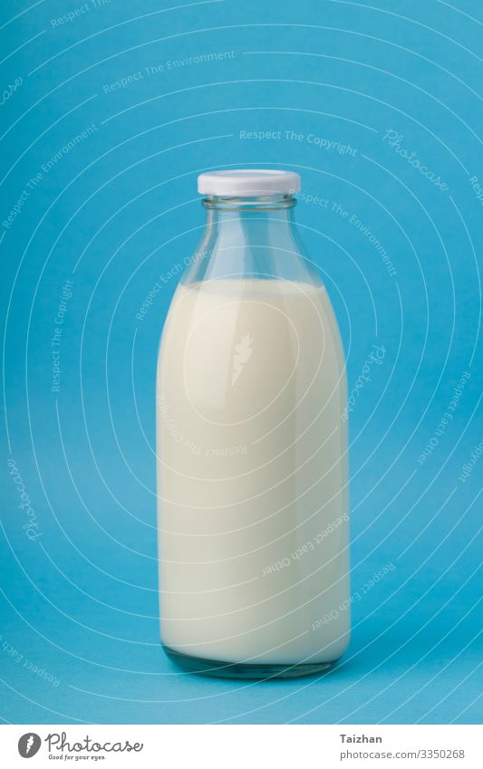 Milk in glass bottle on blue background. close up Breakfast Beverage Bottle Lifestyle Nature Container Cow Cool (slang) Fresh Natural Clean Blue White Colour