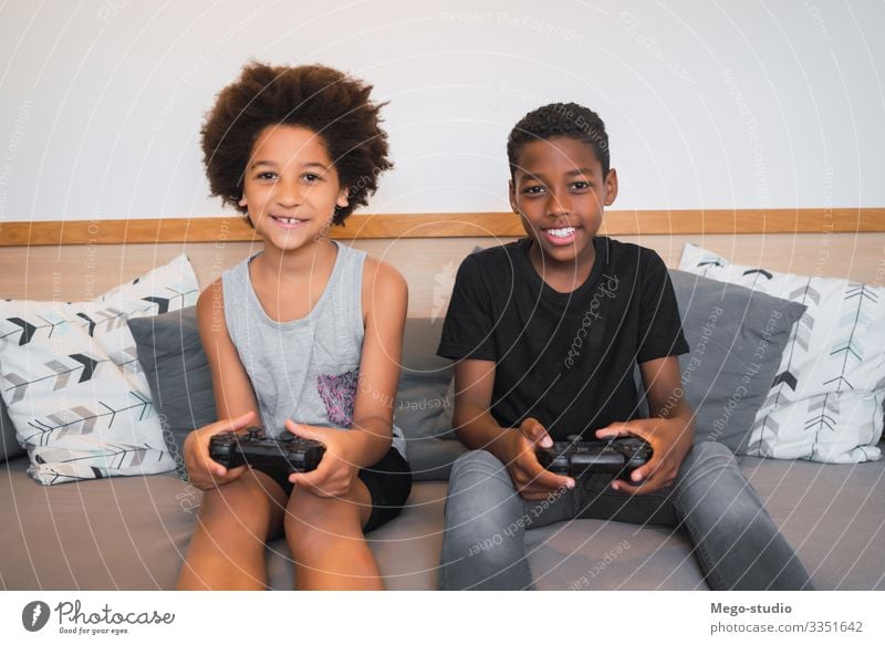 Two brothers playing video games at home. Lifestyle Joy Happy Leisure and hobbies Playing Sofa Entertainment Child Technology Human being Boy (child)